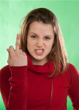 defiant - Teenage Girl Giving the Middle Finger Foto de stock - Sin royalties Premium, Código: 600-03456225