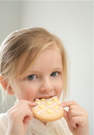 Petite fille mangeant un biscuit de Pâques Photographie de stock - Premium Libres de Droits, Code: 600-03456686