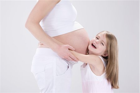 pregnant lady belly - Little Girl Hugging Pregnant Mother Foto de stock - Sin royalties Premium, Código: 600-03451341