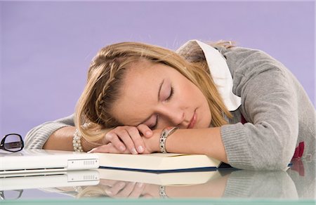 person sleeping at desk - Jeune femme s'endormir au bureau Photographie de stock - Premium Libres de Droits, Code: 600-03451513