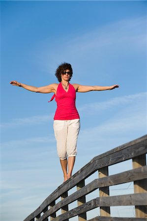 Woman Balancing on Wooden Railing, Honeymoon Island State Park, Florida,USA Stock Photo - Premium Royalty-Free, Code: 600-03484700