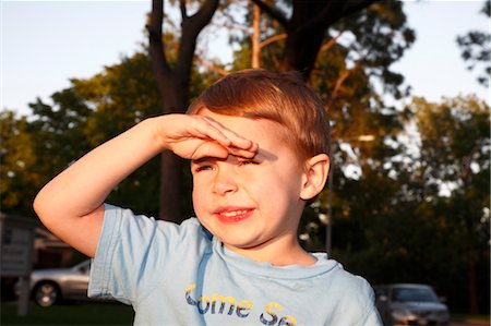 Close-up of Boy Shading Eyes from Sun Stock Photo - Premium Royalty-Free, Code: 600-03485065