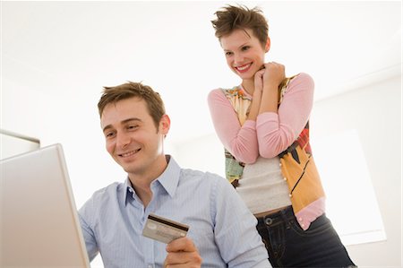 people happy surprise computer - Young Couple with Credit Card and using Computer Stock Photo - Premium Royalty-Free, Code: 600-03508480