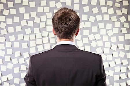 Businessman Looking at a Wall Full of Self Adhesive Notes Fotografie stock - Premium Royalty-Free, Codice: 600-03520294