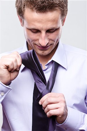 putting on tie - Businessman Putting on Tie Stock Photo - Premium Royalty-Free, Code: 600-03520292