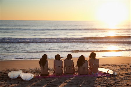 Backview des jeunes femmes avec des planches de surf, assis sur la plage en regardant le coucher du soleil, Zuma Beach, Californie, USA Photographie de stock - Premium Libres de Droits, Code: 600-03520706