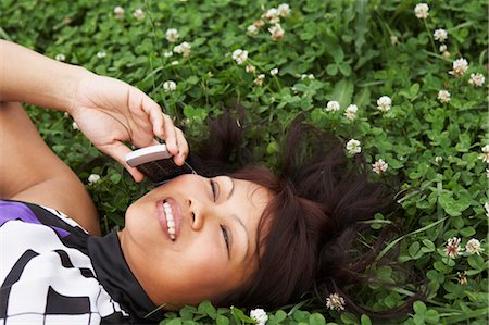 Woman Lying in Clover Field Talking on Cell Phone, North Carolina, USA Foto de stock - Sin royalties Premium, Código: 600-03544739