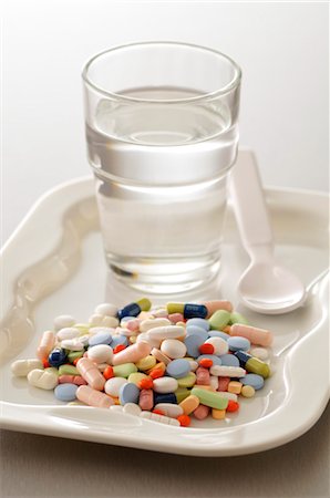 Assorted Medication and Glass of Water Stock Photo - Premium Royalty-Free, Code: 600-03601397