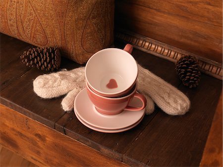 Cups and Saucers, Mittens, and Pine Cones on Bench Foto de stock - Royalty Free Premium, Número: 600-03692038