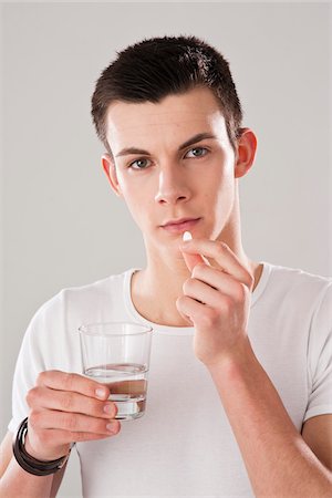 Young Man Taking Pill Stock Photo - Premium Royalty-Free, Code: 600-03777810