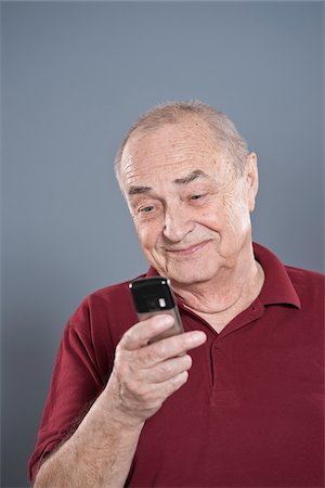 senior looking at phone - Man Using Cellular Telephone Stock Photo - Premium Royalty-Free, Code: 600-03777831