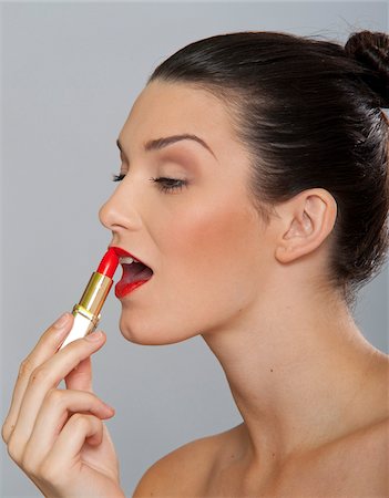 Woman Applying Lipstick Foto de stock - Sin royalties Premium, Código: 600-03787528