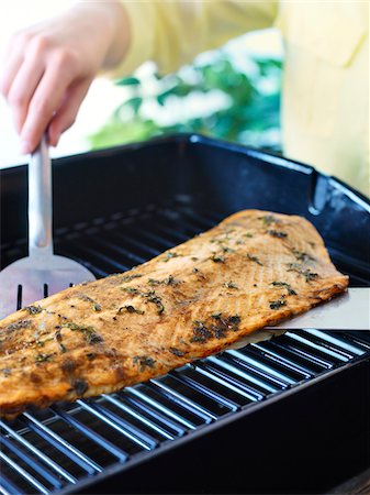 simsearch:695-03375511,k - Woman using Barbeque Tools to remove Salmon from Grill Stock Photo - Premium Royalty-Free, Code: 600-03849755