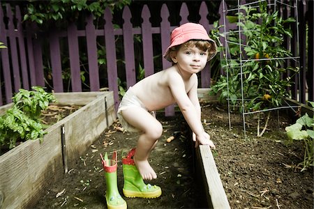 Enfant en bas âge jouer dans le jardin Photographie de stock - Premium Libres de Droits, Code: 600-03979830