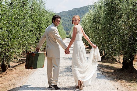 simsearch:6122-08212505,k - Newlyweds walking on country road with suitcase Foto de stock - Royalty Free Premium, Número: 614-05399403