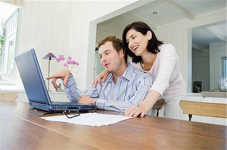 people and internet banking - Couple using laptop in kitchen Stock Photo - Premium Royalty-Free, Code: 614-05399657
