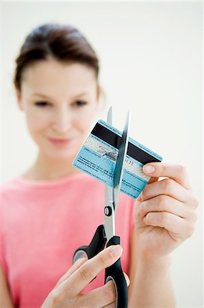 debt - Woman cutting credit card with pair of scissors Stock Photo - Premium Royalty-Free, Code: 614-05399688