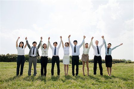 support - Businesspeople in a row in field, arms up Stock Photo - Premium Royalty-Free, Code: 614-05399778