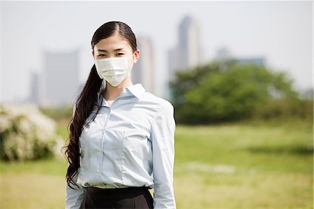 Young businesswoman wearing pollution mask Foto de stock - Sin royalties Premium, Código: 614-05399788