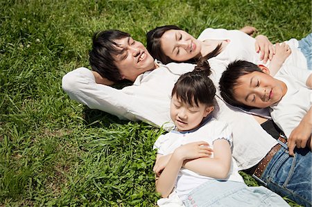 Famille couché sur l'herbe Photographie de stock - Premium Libres de Droits, Code: 614-05399832