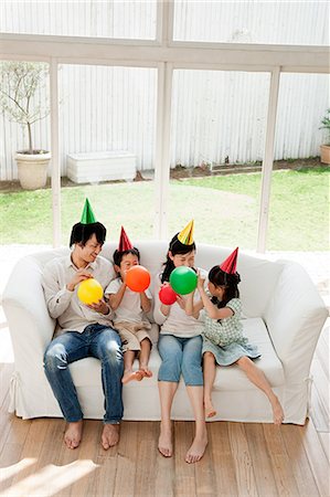 party seated full length couch - Family with two children with balloons Stock Photo - Premium Royalty-Free, Code: 614-05399855