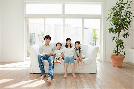 family in living room relaxing - Family with two children on sofa, portrait Stock Photo - Premium Royalty-Free, Code: 614-05399853