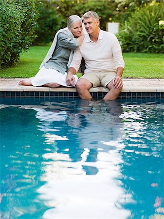 Couple sitting at poolside in garden Stock Photo - Premium Royalty-Free, Code: 614-05399937