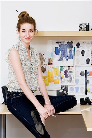 fashion designer (female) - Young female fashion designer sitting on desk, portrait Foto de stock - Sin royalties Premium, Código: 614-05522966