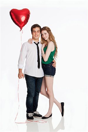 Young couple with balloon against white background Stock Photo - Premium Royalty-Free, Code: 614-05523041