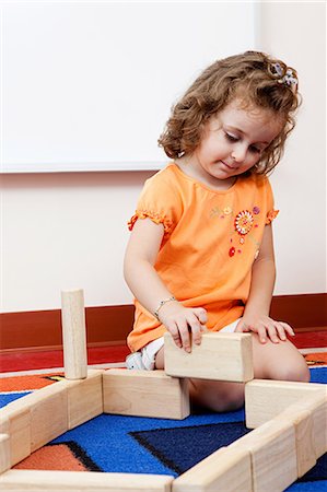 daycare on floor - Girl playing with building blocks Stock Photo - Premium Royalty-Free, Code: 614-05523131