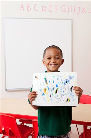 Boy holding picture that he has drawn in school Foto de stock - Sin royalties Premium, Código: 614-05523156