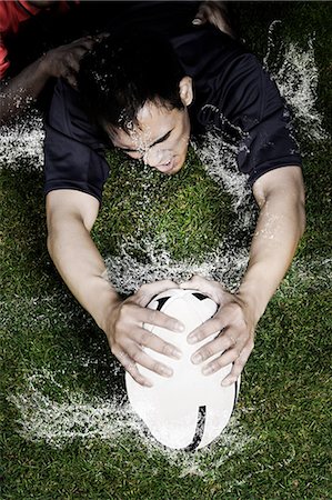 rugby - Tacle de rugby sur un sol humide Photographie de stock - Premium Libres de Droits, Code: 614-05523164