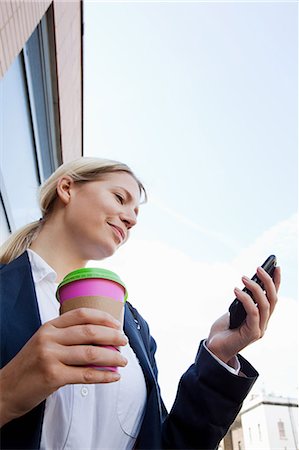 Businesswoman with coffee and smart phone Stock Photo - Premium Royalty-Free, Code: 614-05556685