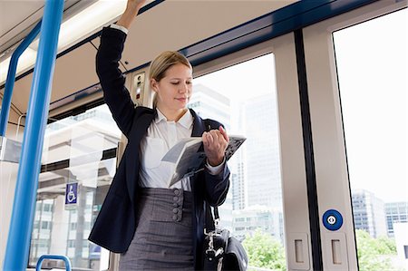 Businesswoman travelling on train with book Stock Photo - Premium Royalty-Free, Code: 614-05556703