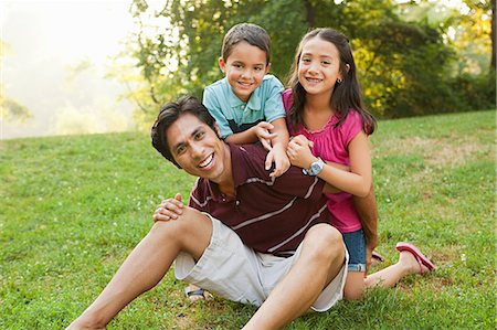 father and sons and fun and outdoors and male and three people - Father sitting with children in park, portrait Stock Photo - Premium Royalty-Free, Code: 614-05556852