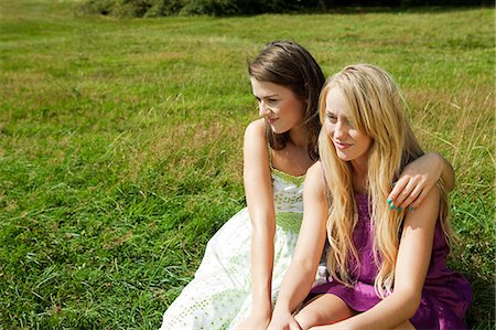 sundress - Young lesbian couple sitting side by side in a field Stock Photo - Premium Royalty-Free, Code: 614-05557088