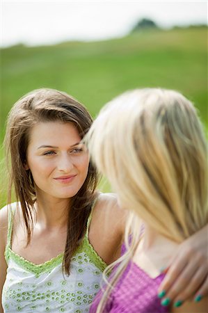 simsearch:614-02074199,k - Young lesbian couple looking at each other intimately while sitting in the countryside Foto de stock - Sin royalties Premium, Código: 614-05557089