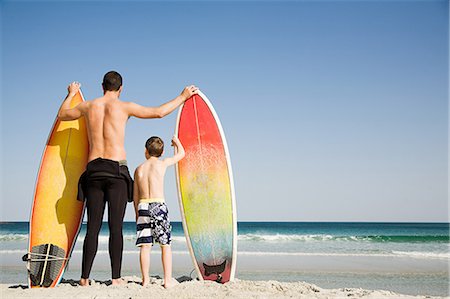 surf (waves hitting shoreline) - Father and son with surfboards gazing out to sea Foto de stock - Sin royalties Premium, Código: 614-05557164