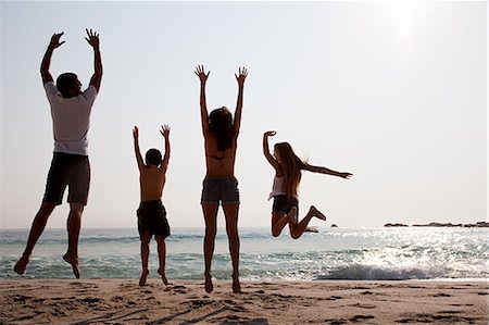 preteen girl arms raised - Family jumping up in the air on a beach Stock Photo - Premium Royalty-Free, Code: 614-05557194