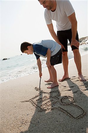 drawing picture on parents - Boy drawing a picture of a car in the sand Stock Photo - Premium Royalty-Free, Code: 614-05557193