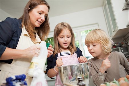 Mid adult woman baking with son and daughter in kitchen Stock Photo - Premium Royalty-Free, Code: 614-05557417