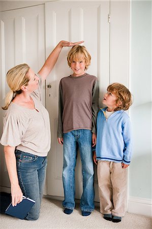 elevado - Mother measuring her sons at home Foto de stock - Sin royalties Premium, Código: 614-05650620