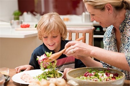 family meals indoors - Mother serving salad to son at dining table Stock Photo - Premium Royalty-Free, Code: 614-05650638