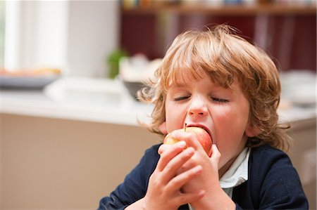 Jeune garçon mange une pomme Photographie de stock - Premium Libres de Droits, Code: 614-05650653