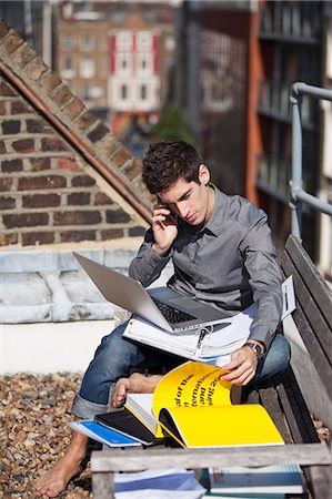 Jeune homme travaillant avec un ordinateur portable sur un toit Photographie de stock - Premium Libres de Droits, Code: 614-05650702