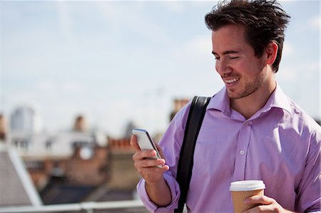 Man looking at mobile phone Stock Photo - Premium Royalty-Free, Code: 614-05650710