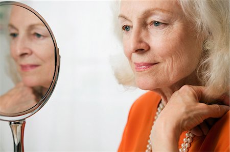 Senior woman with reflection in mirror Stock Photo - Premium Royalty-Free, Code: 614-05650746