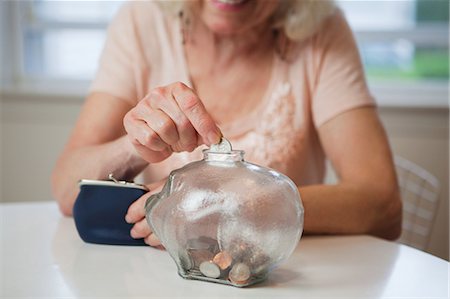 finance retirement - Senior woman saving money in piggy bank Foto de stock - Sin royalties Premium, Código: 614-05650748