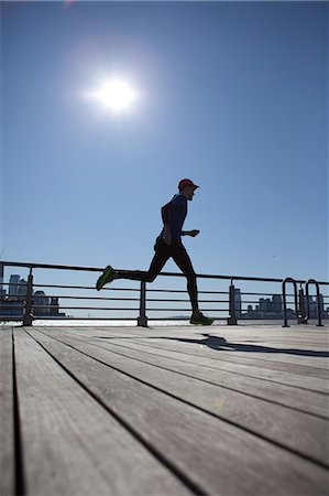 profile runner - Man running across bridge Stock Photo - Premium Royalty-Free, Code: 614-05650888