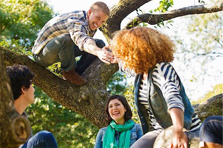 energetic - Mid adult man in tree reaching for friends Stock Photo - Premium Royalty-Free, Code: 614-05650942